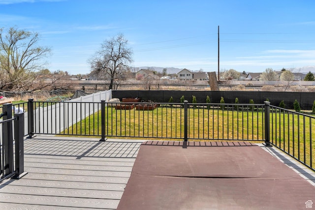 deck featuring a fenced backyard, a residential view, and a lawn