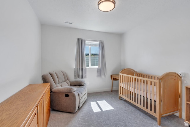 bedroom with light carpet, visible vents, and a nursery area