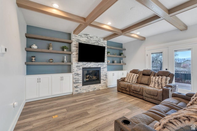 living area with baseboards, built in shelves, light wood-type flooring, beam ceiling, and coffered ceiling