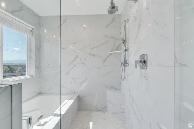 bathroom featuring a marble finish shower and a tub to relax in