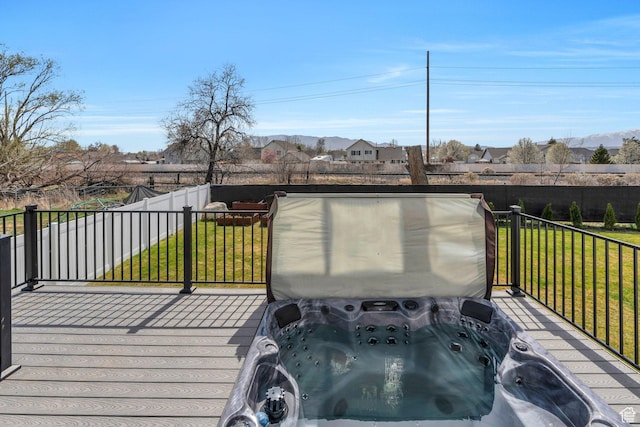 deck featuring a yard and a covered hot tub