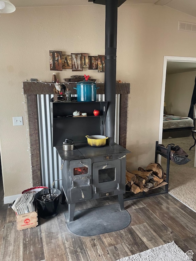 room details with visible vents, wood finished floors, and a wood stove