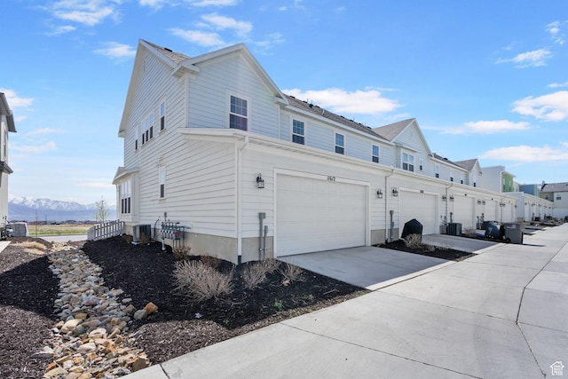 11612 S Watercourse Rd W, South Jordan, UT 84009 - view of side of property with a mountain view, a garage, driveway, and central AC