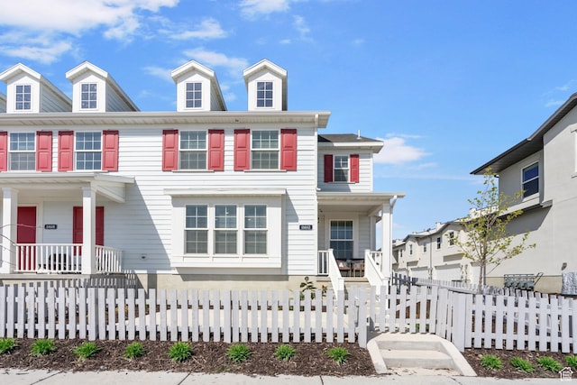 view of front of property featuring a porch and a fenced front yard