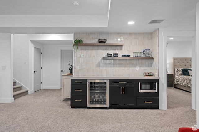 bar featuring built in microwave, visible vents, a dry bar, wine cooler, and light colored carpet
