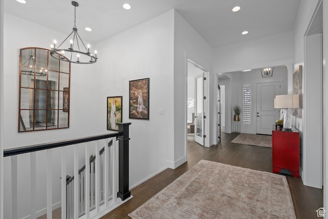 hall with recessed lighting, a notable chandelier, dark wood-style flooring, and baseboards