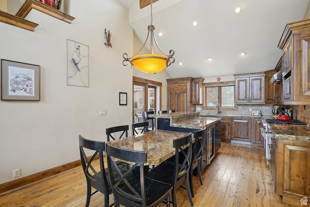 1335 Deer Valley Dr S, Park City, UT 84060 - kitchen featuring light wood-type flooring, dark stone countertops, a center island, appliances with stainless steel finishes, and decorative backsplash
