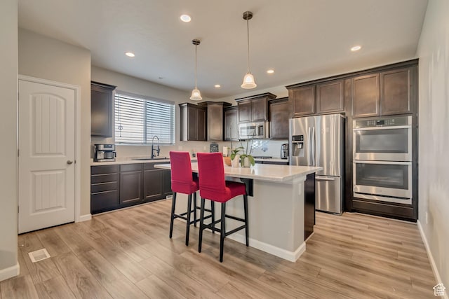 15191 S Ronaldo Ln, Herriman, UT 84096 - kitchen featuring dark brown cabinets, a center island, light countertops, a sink, and stainless steel appliances