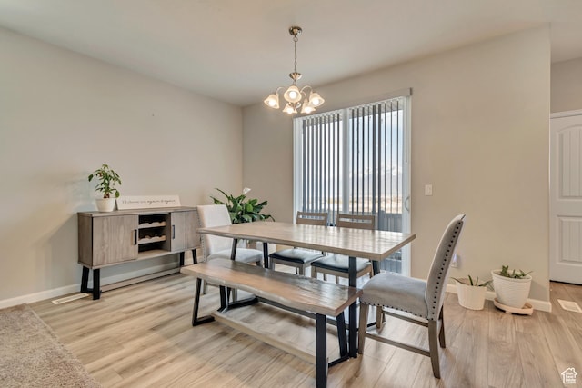 15191 S Ronaldo Ln, Herriman, UT 84096 - dining area with light wood-style floors, a notable chandelier, and baseboards