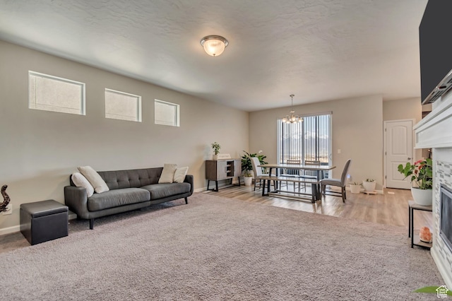 15191 S Ronaldo Ln, Herriman, UT 84096 - living area featuring a glass covered fireplace, baseboards, a notable chandelier, and light carpet