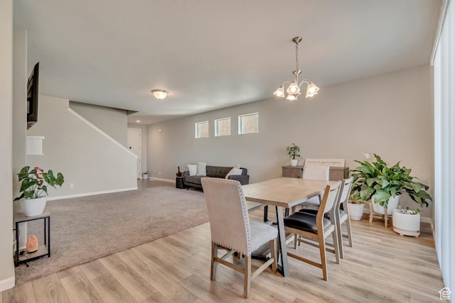 15191 S Ronaldo Ln, Herriman, UT 84096 - dining area featuring baseboards, an inviting chandelier, light wood-style floors, and stairs