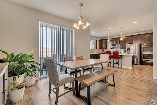 15191 S Ronaldo Ln, Herriman, UT 84096 - dining area with baseboards, light wood-type flooring, a notable chandelier, and recessed lighting