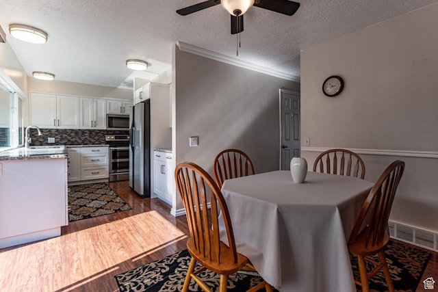 1357 E Ridgewood Ln S, Bountiful, UT 84010 - dining area with dark wood-type flooring, a textured ceiling, a ceiling fan, and visible vents
