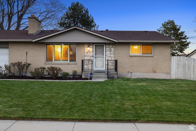 3168 W Ryan Dr, Taylorsville, UT 84129 - view of front of house with brick siding, a chimney, fence, and a front lawn