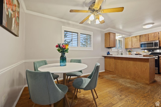 3168 W Ryan Dr, Taylorsville, UT 84129 - dining space featuring light wood-style flooring, a ceiling fan, ornamental molding, and baseboards