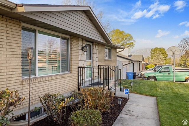 3168 W Ryan Dr, Taylorsville, UT 84129 - entrance to property featuring brick siding, a mountain view, and a lawn
