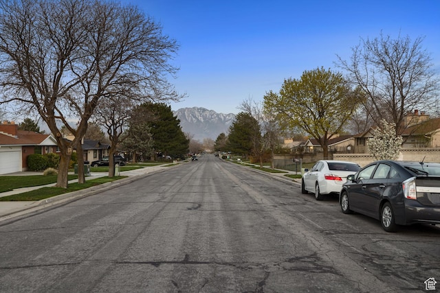 3168 W Ryan Dr, Taylorsville, UT 84129 - view of street featuring sidewalks, curbs, a mountain view, and a residential view