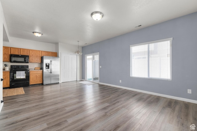 kitchen featuring a chandelier, visible vents, black appliances, and wood finished floors