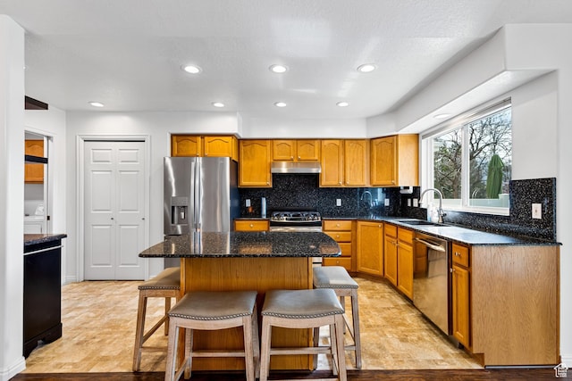 1181 W 4550 S Unit 26, Riverdale, UT 84405 - kitchen featuring stainless steel appliances, a sink, under cabinet range hood, a breakfast bar, and backsplash