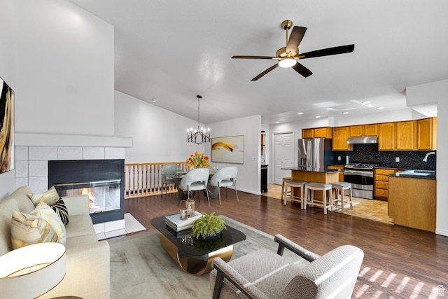 1181 W 4550 S Unit 26, Riverdale, UT 84405 - living room with ceiling fan, wood finished floors, vaulted ceiling, a chandelier, and a tiled fireplace