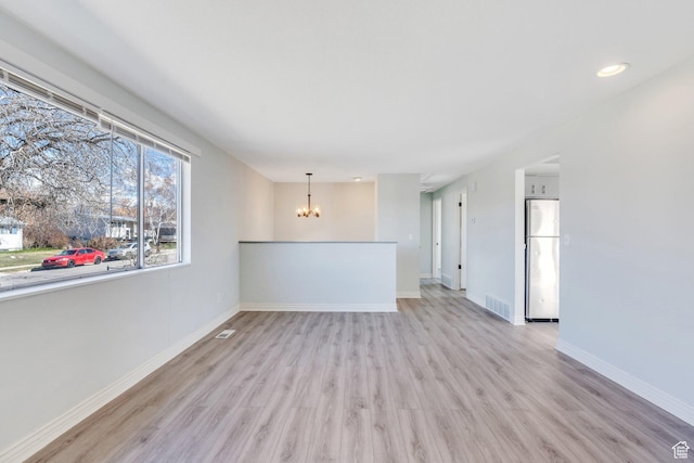 794 N Amethyst St, Layton, UT 84041 - unfurnished living room with a notable chandelier, baseboards, visible vents, and light wood-style flooring