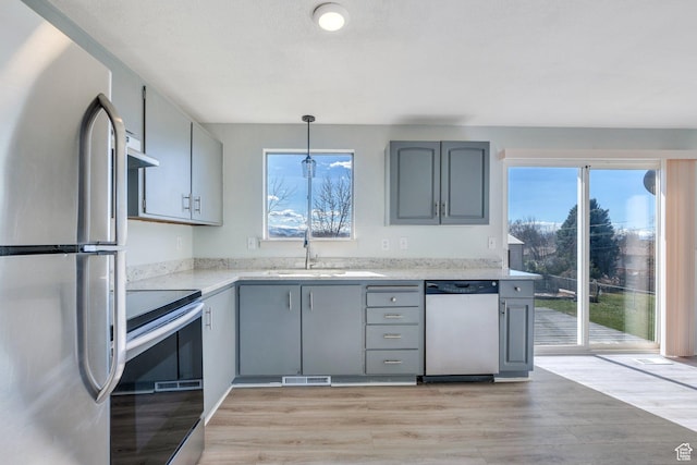 794 N Amethyst St, Layton, UT 84041 - kitchen featuring gray cabinets, under cabinet range hood, appliances with stainless steel finishes, light wood finished floors, and a sink