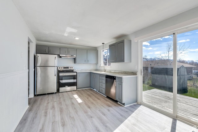 794 N Amethyst St, Layton, UT 84041 - kitchen featuring a sink, light countertops, under cabinet range hood, gray cabinetry, and stainless steel appliances