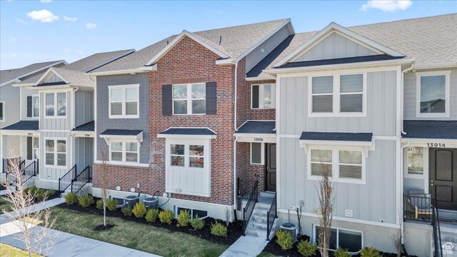 townhome / multi-family property with board and batten siding and roof with shingles