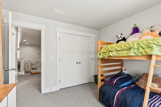 carpeted bedroom with a closet, baseboards, and visible vents