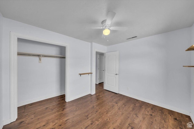 unfurnished bedroom with a closet, a ceiling fan, visible vents, wood finished floors, and baseboards