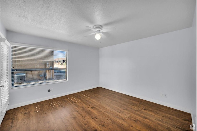 spare room featuring baseboards, a ceiling fan, wood finished floors, and a textured ceiling