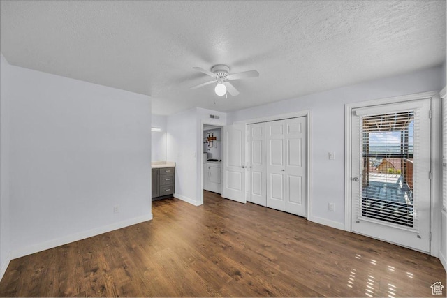 unfurnished bedroom featuring baseboards, dark wood-style floors, access to exterior, and a textured ceiling