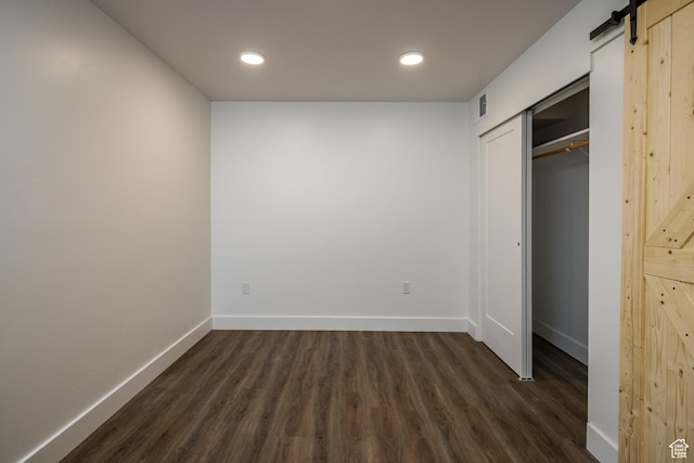 443 Kane Creek Blvd Unit B108, Moab, UT 84532 - unfurnished bedroom with baseboards, recessed lighting, a barn door, visible vents, and dark wood finished floors