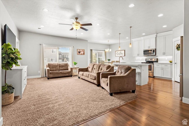 249 N 590 E, Vineyard, UT 84059 - living room with baseboards, a textured ceiling, recessed lighting, wood finished floors, and ceiling fan with notable chandelier