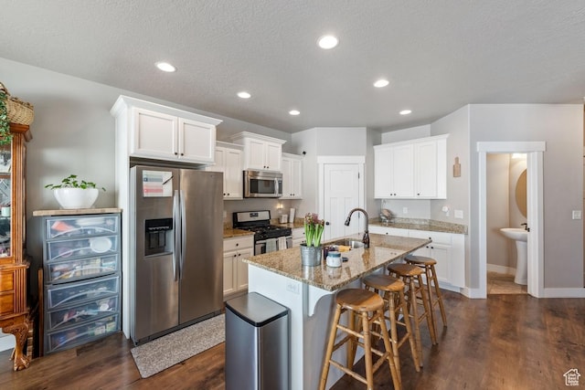 2046 W Fairway Ln, Orem, UT 84058 - kitchen with dark wood-type flooring, appliances with stainless steel finishes, a sink, and light stone countertops