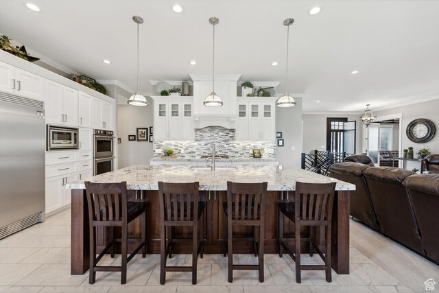 1375 S Red Filly Rd, Heber City, UT 84032 - kitchen with crown molding, glass insert cabinets, a sink, open floor plan, and built in appliances