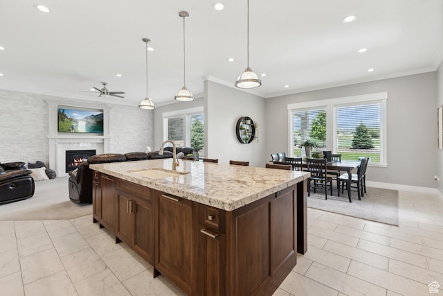 1375 S Red Filly Rd, Heber City, UT 84032 - kitchen with dark brown cabinetry, a lit fireplace, crown molding, ceiling fan, and a sink