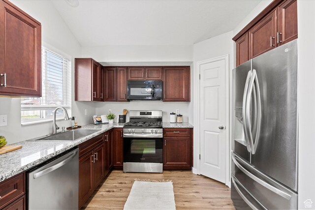 2124 N 2525 W, Clinton, UT 84015 - kitchen featuring light stone countertops, a sink, lofted ceiling, stainless steel appliances, and light wood finished floors