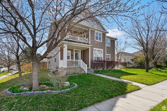 view of front facade featuring fence, a front lawn, and a balcony