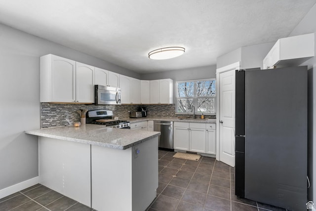 1468 N 220 W, Tooele, UT 84074 - kitchen with a sink, backsplash, appliances with stainless steel finishes, and a peninsula