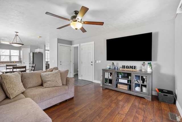 1468 N 220 W, Tooele, UT 84074 - living area with dark wood-type flooring, a textured ceiling, a ceiling fan, visible vents, and baseboards