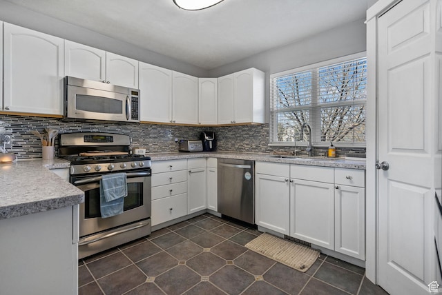 1468 N 220 W, Tooele, UT 84074 - kitchen featuring dark tile patterned flooring, backsplash, white cabinets, and stainless steel appliances