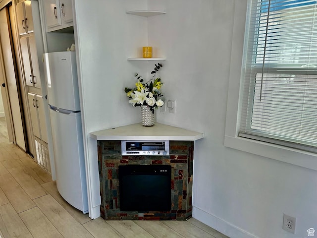 1160 E Telegraph St Unit 126, Washington, UT 84780 - interior space with freestanding refrigerator, wood finish floors, open shelves, white cabinets, and light countertops