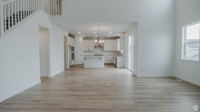 876 W Sika Cir S Unit 205, Saratoga Springs, UT 84045 - unfurnished living room with recessed lighting, light wood-type flooring, and a high ceiling