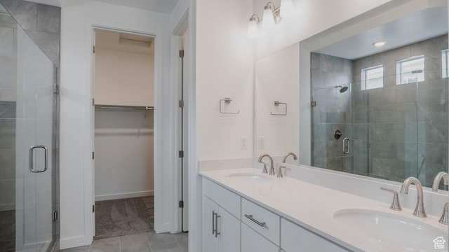 876 W Sika Cir S Unit 205, Saratoga Springs, UT 84045 - bathroom featuring a shower stall, a spacious closet, double vanity, and tile patterned flooring