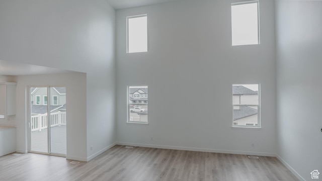 876 W Sika Cir S Unit 205, Saratoga Springs, UT 84045 - empty room featuring light wood-type flooring, plenty of natural light, and a towering ceiling