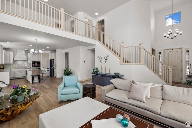 814 N 1490 E, Heber City, UT 84032 - living area with baseboards, a notable chandelier, light wood-style floors, stairway, and a towering ceiling