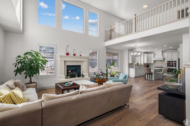 814 N 1490 E, Heber City, UT 84032 - living area with a glass covered fireplace, baseboards, an inviting chandelier, recessed lighting, and wood-type flooring