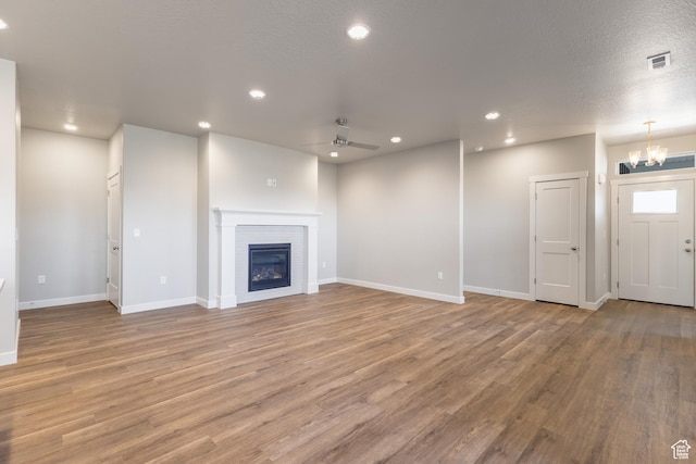 3778 S 4250 W Unit 435, West Haven, UT 84401 - unfurnished living room featuring wood finished floors, a chandelier, ceiling fan, recessed lighting, and a glass covered fireplace