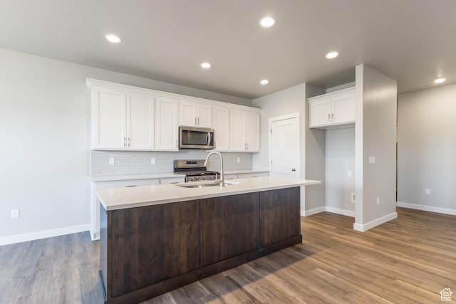 3778 S 4250 W Unit 435, West Haven, UT 84401 - kitchen with appliances with stainless steel finishes, a kitchen island with sink, decorative backsplash, wood finished floors, and recessed lighting